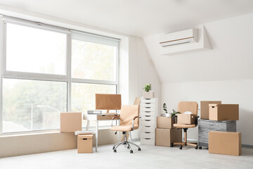 Desk with chairs and moving boxes in office