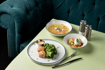 Freshly prepared dishes showcase vibrant ingredients, placed beautifully on a green tablecloth in a cozy dining space. Bright colors and rich textures invite a delightful meal