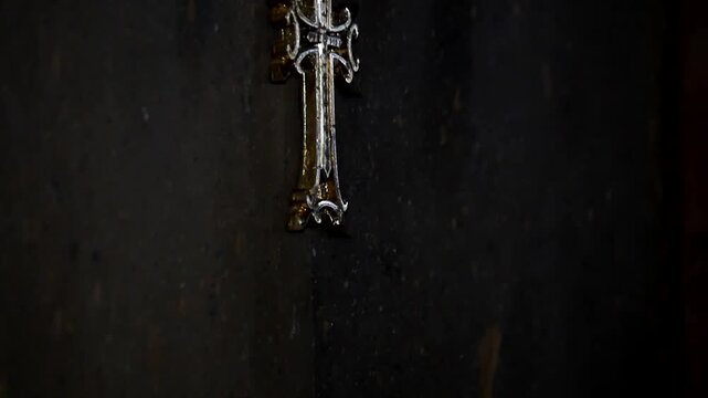 interior view of a stone church featuring a painting of Jesus Christ on the wall. Below stands a stone baptismal font and a red ceremonial stand.