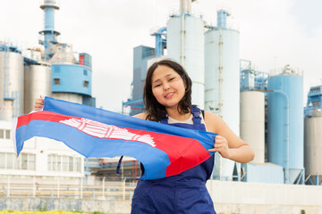 National flag of Cambodia in the hands of girl in overalls against background of a modern...