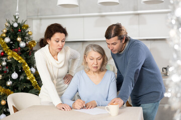 Adult married couple helps elderly woman make will testament, declaration for loan, application for settlement in nursing home during winter holiday