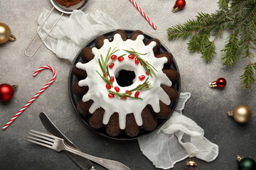 Delicious Christmas cake with pomegranate and glaze on grunge grey background, top view