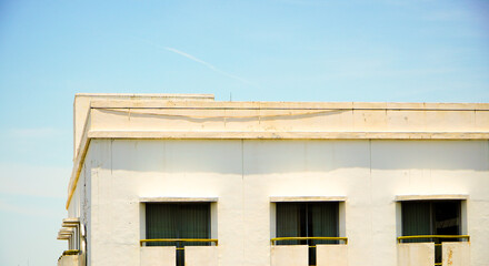 Front view of a tall hotel building with a bright blue cloudy sky in the background. Window hotel with vintage design in center of the town. Hotel at the city metropolitan concept