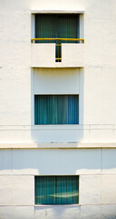 windows on the wall. Front view of a tall hotel building with a bright blue cloudy sky in the background. Window hotel with vintage design in center of the town. Hotel at the city metropolitan concept