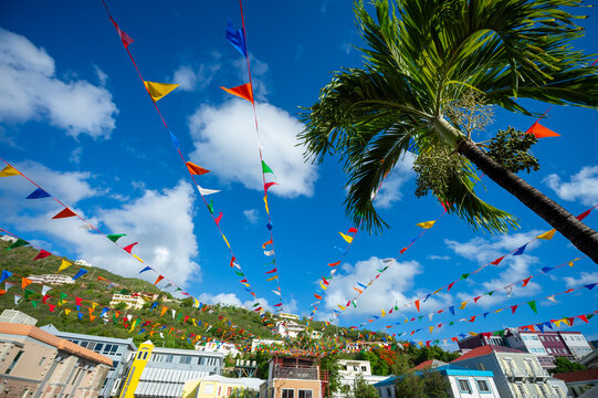 Carnival bunting flags strewn from building and palm trees across a plaza in Road Town, Tortola in the Caribbean
