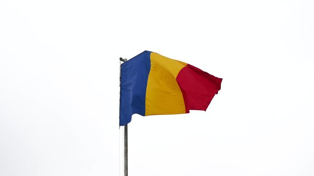The Romanian flag waves gracefully in the wind, showcasing its vibrant blue, yellow, and red colors.