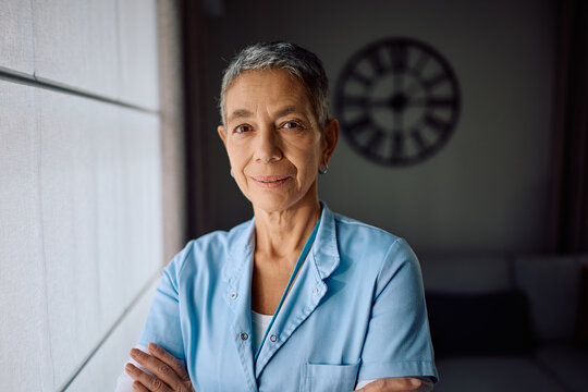 Portrait of mature nurse during home visit looking at camera. - Powered by Adobe