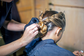 Hairstyling for a ballroom dancing girl at a tournament.