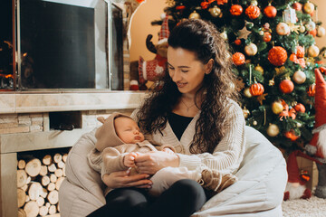 Mother holding sleeping baby celebrating christmas holidays