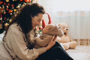 Mother holding baby, celebrating christmas at home