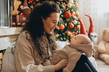 Mother cuddling baby during christmas celebration