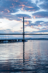 Obraz premium An evening photo of the Queensferry Crossing over the Firth of Forth, with reflections and a blue glow.