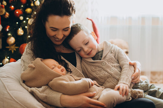 Mother embracing happy children during christmas holidays