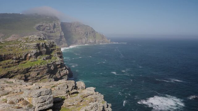 View of Cape Point from the Cape of Good Hope with the upper lighthouse shrouded in mist, which is why the lower one was built. Table Mountain National Park. Cape Town. Western Cape. South Africa.: