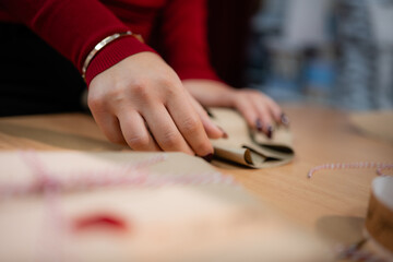 Woman hands wrapping christmas gift with brown paper