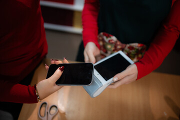 Customer making contactless payment with smartphone at pos terminal