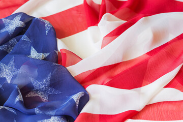 Close-up of American flag fabric with soft folds showing stars and stripes. Independence Day. Concept of freedom, unity, celebration of American spirit, patriotism, national pride