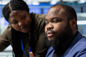 African american team members with technical expertise share insight, collaborating on...