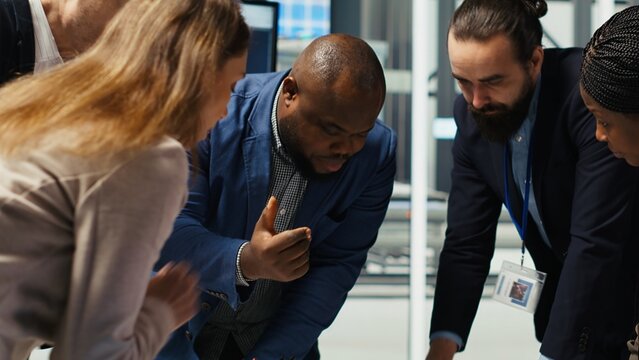 Factory engineers study detailed schematics of solar panel assembly lines, refining production layouts using tablet. Industrial plant experts outlining configurations for new prototypes, camera B