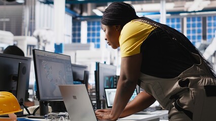 Photovoltaics factory technician designing CAD models and technical sketches for solar modules on laptop. Woman engineer ensures solar panel designs for efficiency and manufacturability. Camera A.
