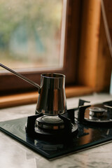 Coffee pot on gas stove near window, cozy warm light