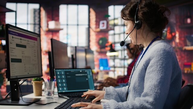 Call center employee starting job shift, sitting down at desk, handling complaints. Customer service agent arriving at work, listening to customer needs related to products or services, camera B