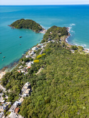 Aerial view of Bombinhas beaches with buildings, sand, rocks and forest