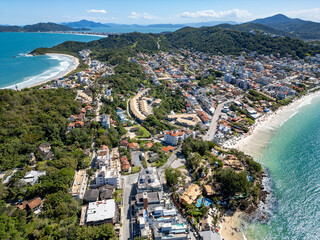 Aerial view of Bombinhas beaches with buildings, sand, rocks and forest