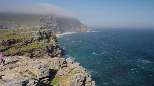 View of Cape Point from the Cape of Good Hope with the upper lighthouse shrouded in mist, which is why the lower one was built. Table Mountain National Park. Cape Town. Western Cape. South Africa.: