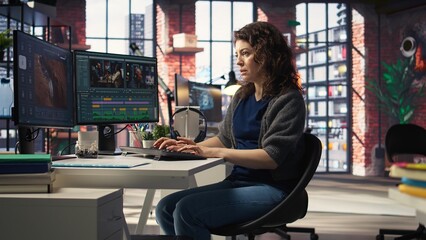 Focused editor woman works on video montage in creative software at agency office, digital media....