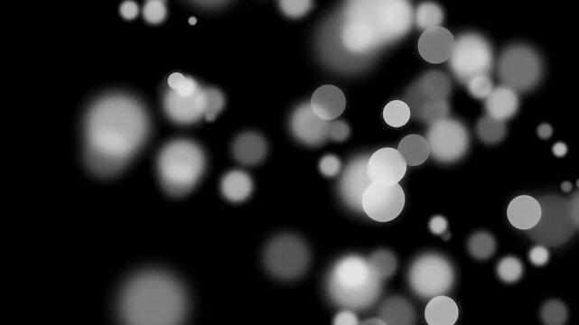 A blurred background with white and gray light circles against a dark surface, creating a soft bokeh effect.