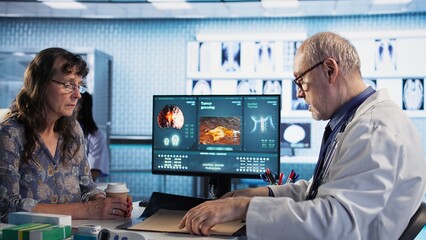 Oncology consultation takes place as a senior medic explains radiology scan, emphasizing preventive medicine and healthy lifestyle recommendations. Shares risk factors and causes. Camera A.