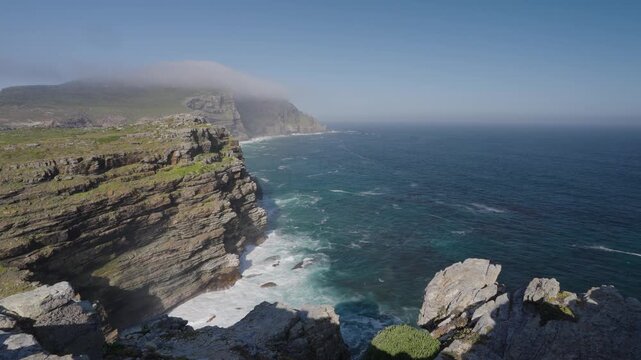 View of Cape Point from the Cape of Good Hope with the upper lighthouse shrouded in mist, which is why the lower one was built. Table Mountain National Park. Cape Town. Western Cape. South Africa.: