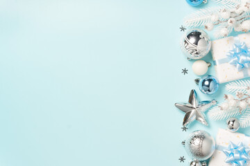 Silver ornaments, white gifts, and festive decorations arranged along the top of a light blue background.