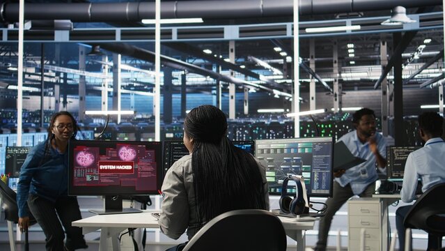 Server hub coworkers react to security breach after unauthorized access bypassing firewall compromising data. Employees initiate emergency response protocols after cybersecurity alert, camera A