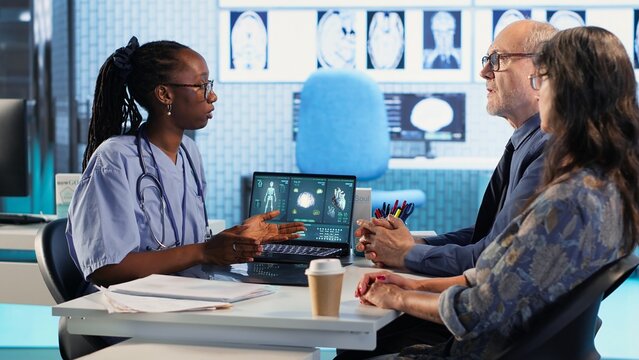 Nurse and patients reviewing diagnostic results in medical cabinet, using advanced healthcare technology to evaluate x ray imaging results and MRI scans. Patient care on insurance. Camera B.