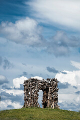 wooden gate on the hill against the background of the cloudy blue sky. Passage through a door made of wood. High quality photo