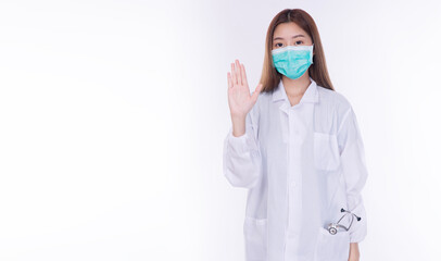 Asian female doctor wearing medical face mask showing stop hand sign gesture. Healthcare worker warning or prohibition concept isolated on white background with copy space for text.