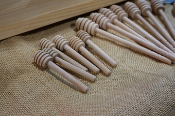 Wooden honey dippers on rustic burlap background