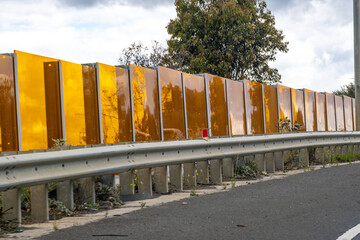 Transparent highway noise barrier panels installed along a roadside in Melbourne, Australia,...