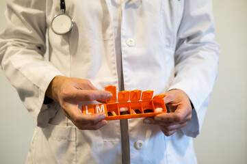 Hands of Healthcare Professional Using a Pill Organizer, Adherence to Medication Schedule