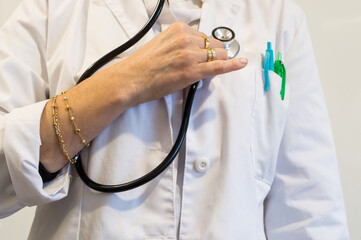 Female Doctor Holding Stethoscope with Rings and Bracelet, Focus on Inappropriate Surgical Attire and Hygiene