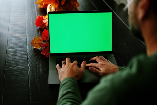 Mature bearded man working remotely on customizable green screen laptop- Perfect for inserting your own app, dashboard, video call, charts, or website