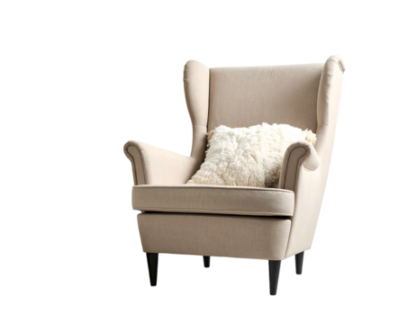 A beige wingback chair with a fluffy white pillow sits against a stark black backdrop