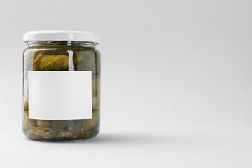 Pickled cucumbers in jar on light background, closeup. Space for text