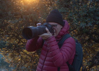 Wildlife Photographer at Golden Hour with Professional Digital Camera and Large Telephoto Lens