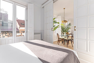 Contemporary bedroom with a double bed featuring an illuminated headboard, glass bedside tables, and a designer dressing chair