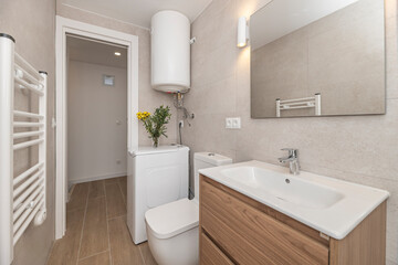 Functional bathroom with a 35 cm deep wall-hung wooden vanity unit and open side shelves, solving storage problems without sacrificing the feeling of spaciousness.