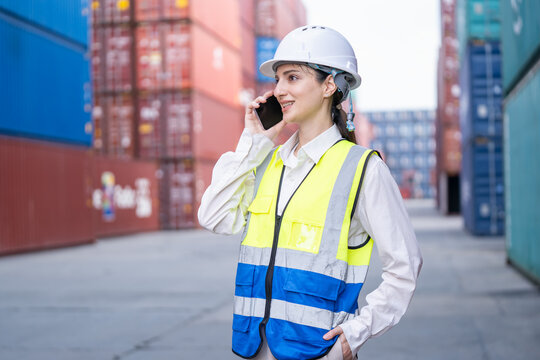 Construction worker on phone shipping yard professional image urban environment side view job coordination