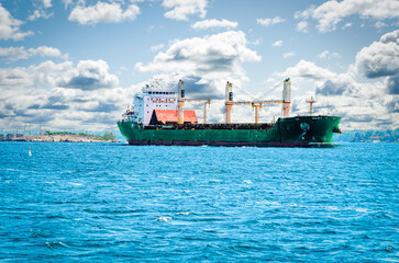 Single frieght ship on the St. Lawrence River under a clouded sky on a bright summer day